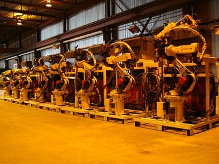 Picture of Fanuc machine tending industrial robots. Robots are lined up, ready to be installed in a Grand Rapids shop. 